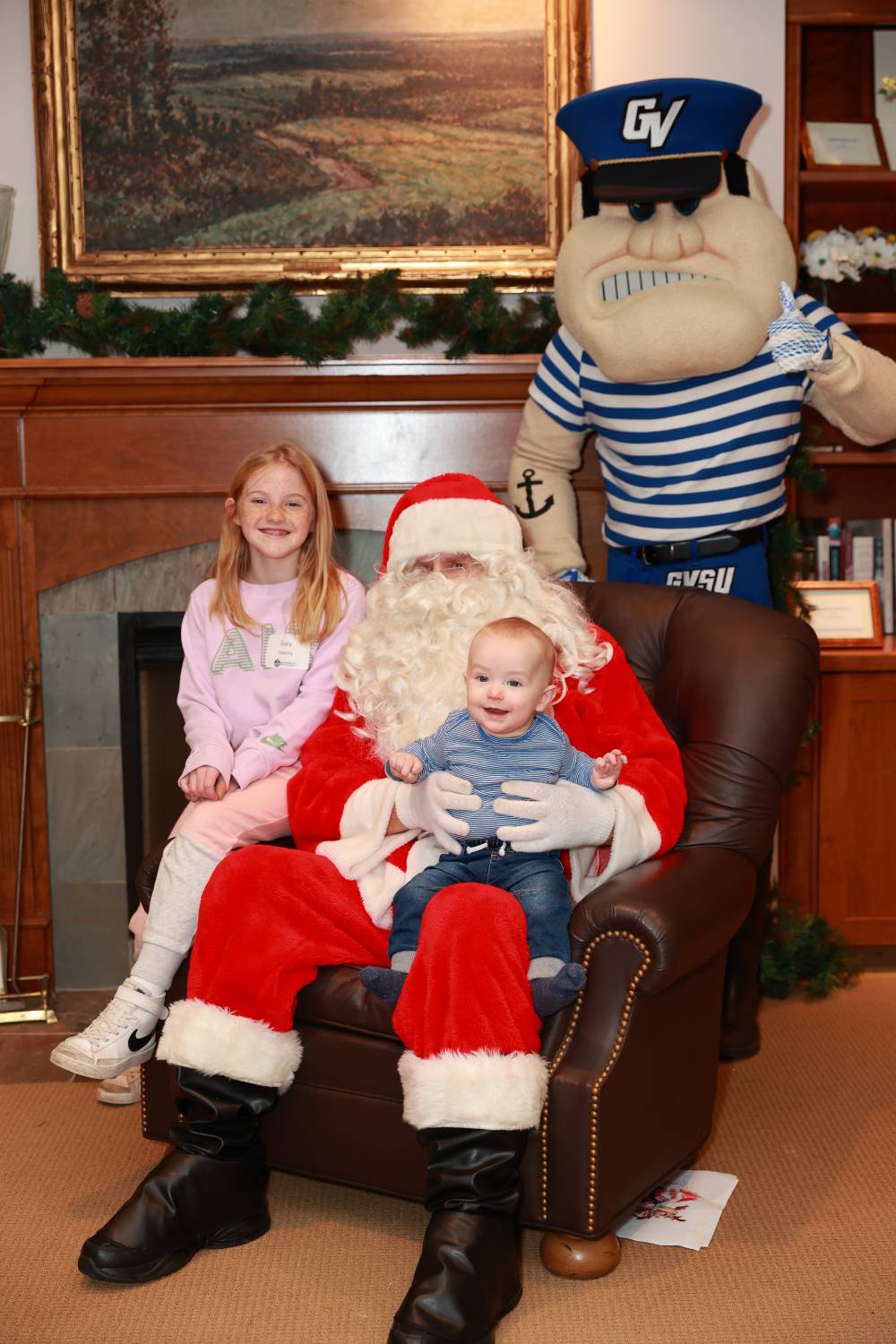 A girl and her little brother with Santa & Louie.